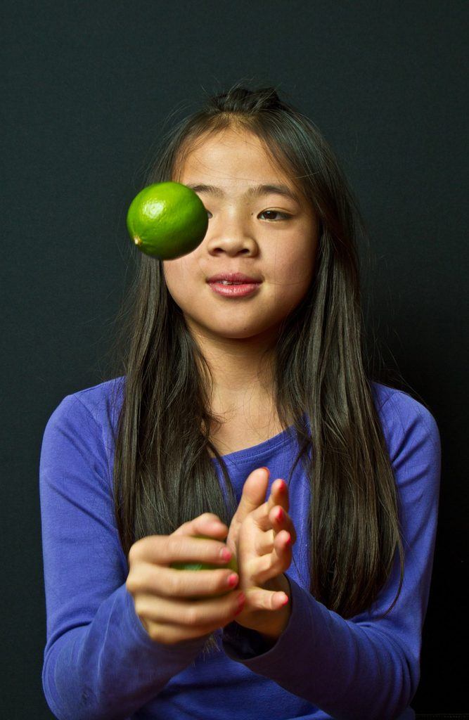 Fillette jouant au ballon avec un citron  ( les jeux de balle sont excellents pour détendre les yeux)